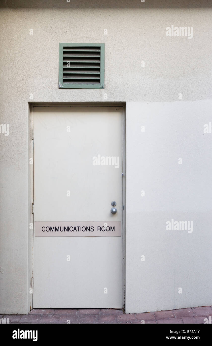 Entrée d'un bloc de bureau blanc à Manly, Sydney, avec un 'fortune' Salle de communications sur la porte. Banque D'Images