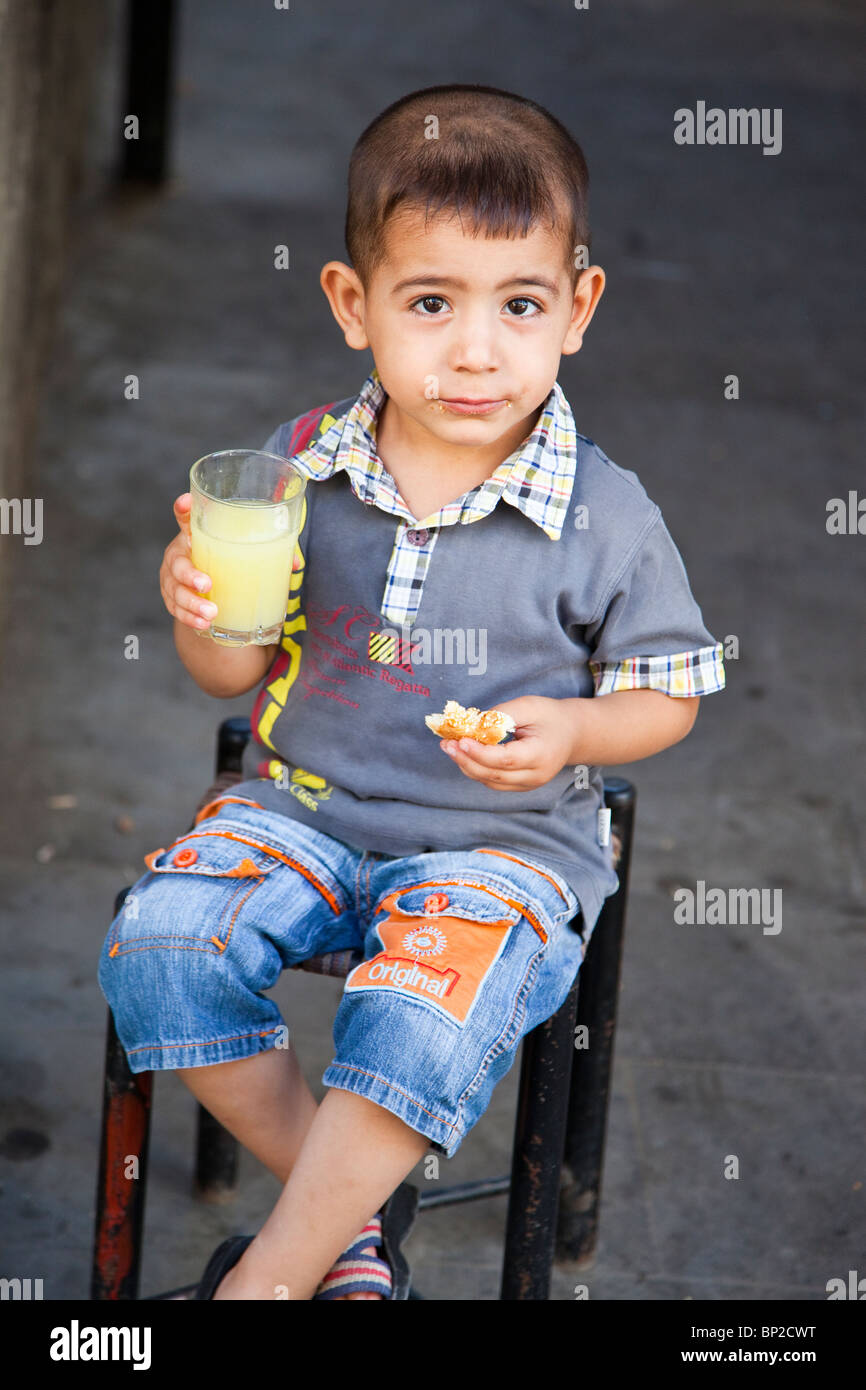 Jeune garçon manger dans la vieille ville de Diyarbakir, est de la Turquie Banque D'Images