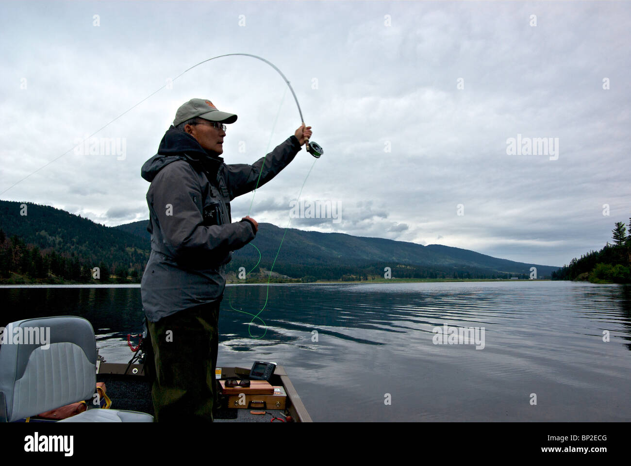 Pêcheur à la mouche avec canne à pêche et de courriers double flou au Mamit Lake BC Banque D'Images