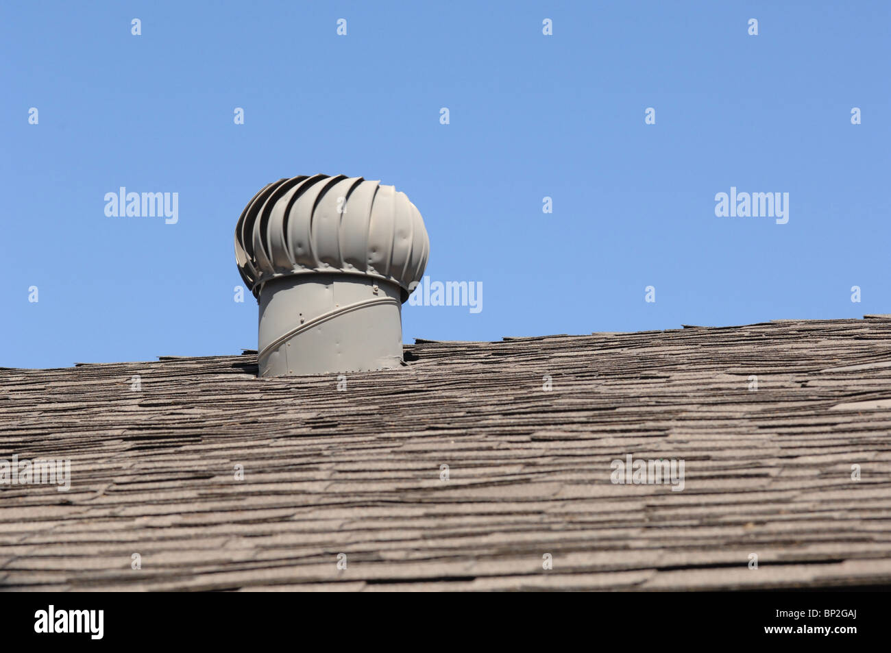 Rotation d'un ventilateur d'extraction passive se trouve au sommet d'un toit de maison en Californie en photo contre un ciel bleu avec des prix pour la copie d'annonce. Banque D'Images