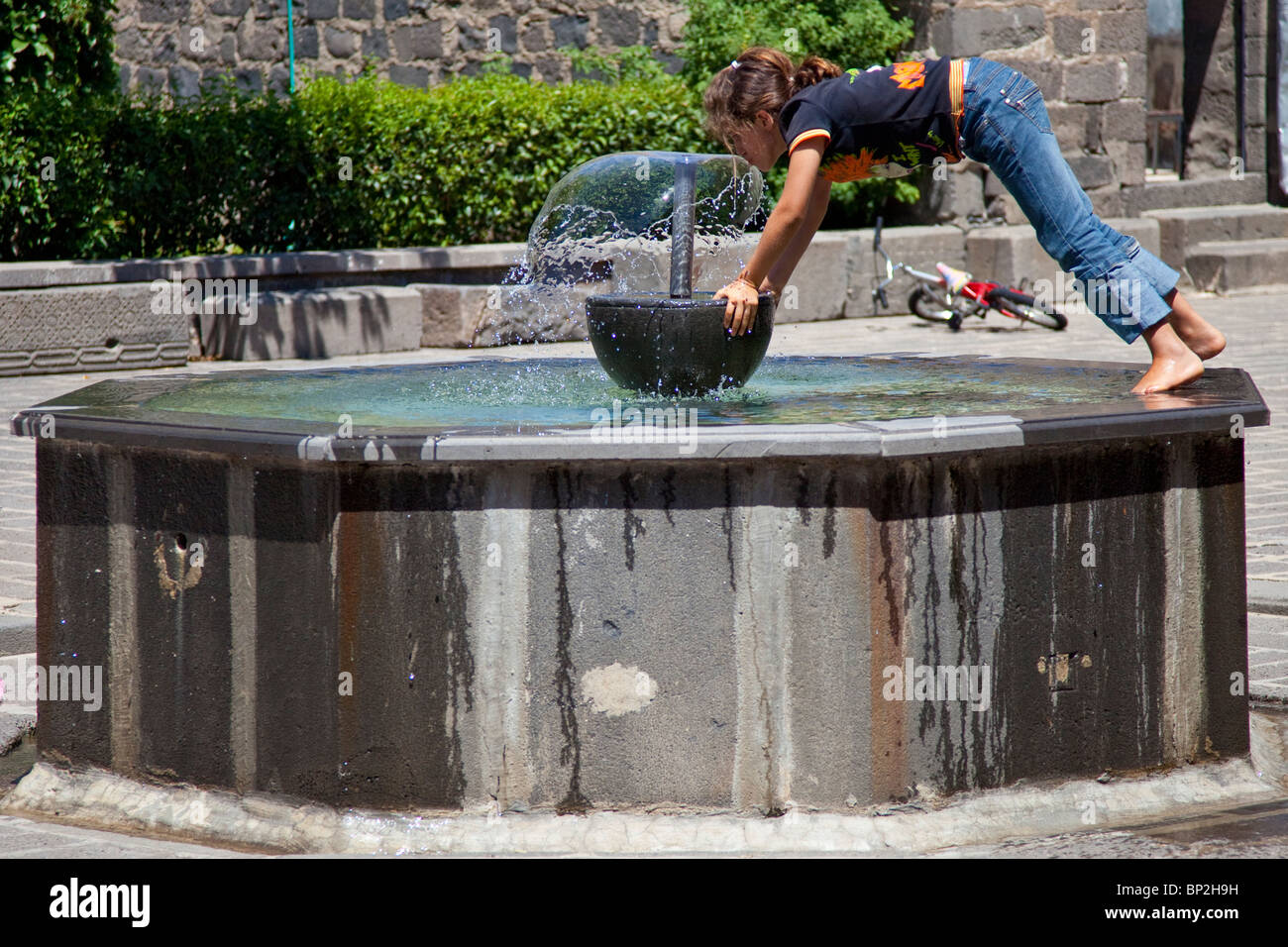 Girl drinking de la fontaine à la Vierge Marie Église syriaque de Diyarbakir, est de la Turquie Banque D'Images