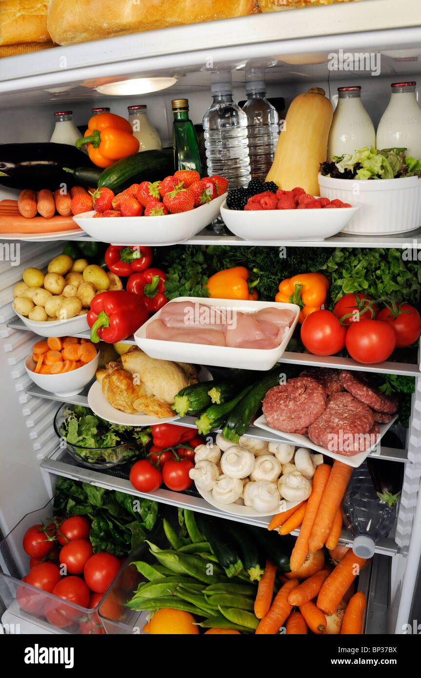 Vue à l'intérieur de réfrigérateur avec des étagères remplies de produits frais Banque D'Images