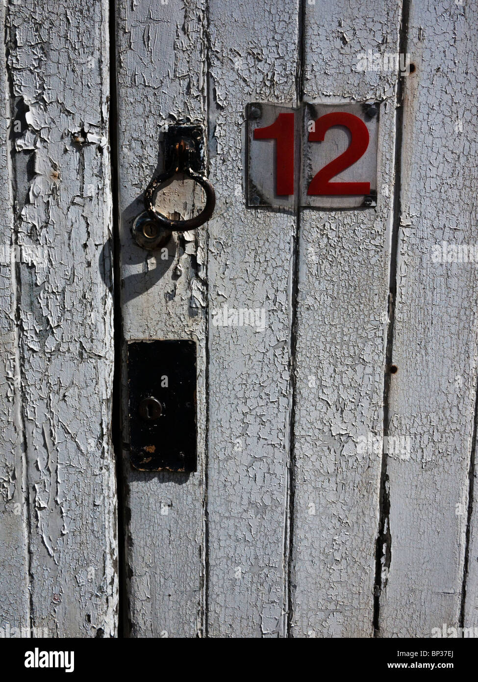 Photo du côté de la serrure de porte avec peeling peinture allumé . Porte  Blanche avec du rouge numéro 12 sur elle Photo Stock - Alamy