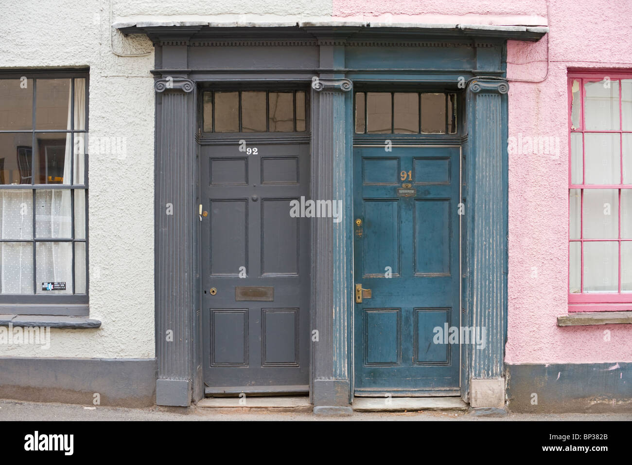 Scruffy lambrissés gris et bleu portes avant no 9291 avec poignée fronton letterbox architrave de période Maisons de village à UK Banque D'Images