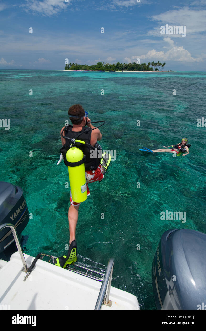 L'homme entrant dans l'eau du bateau pour faire de la plongée, Pom Pom Island Resort, Mer de Célèbes, Sabah, Malaisie Orientale. Banque D'Images