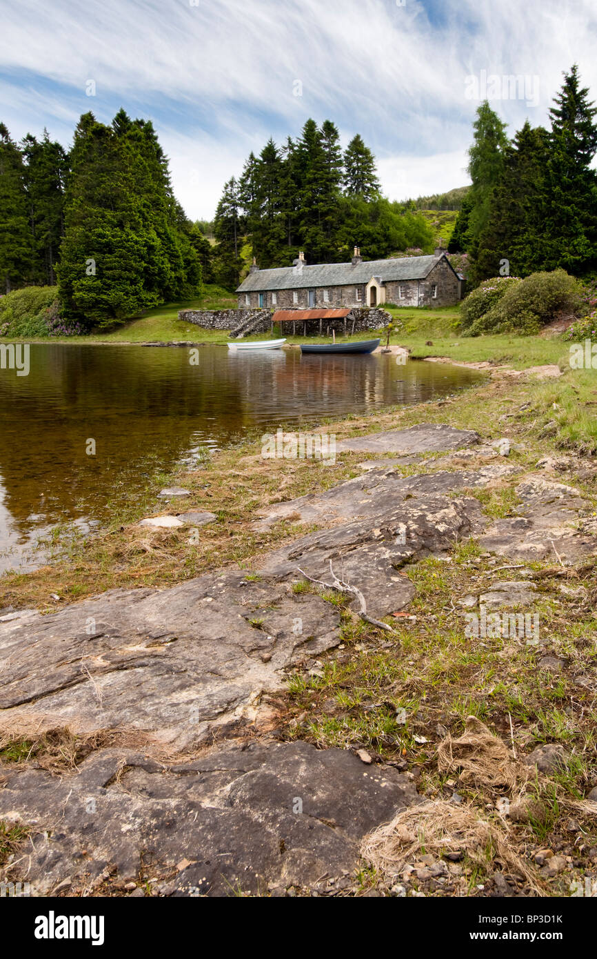 Loch Ordie à distance, près de Dunkeld, Écosse avec old stone cottages, chaloupes & boat house prises à l'été Banque D'Images