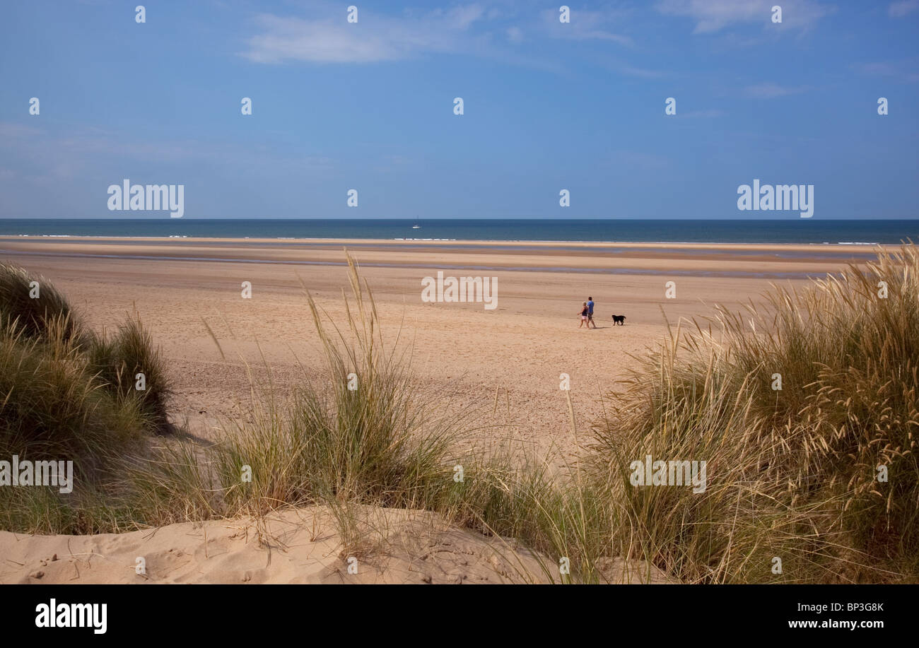 Couple en train de marcher le long de la plage, Holkham, Norfolk, Angleterre Banque D'Images