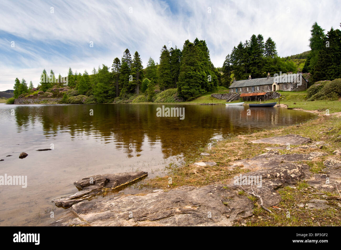 Loch Ordie à distance, près de Dunkeld, Écosse avec old stone cottages, chaloupes & boat house prises à l'été Banque D'Images