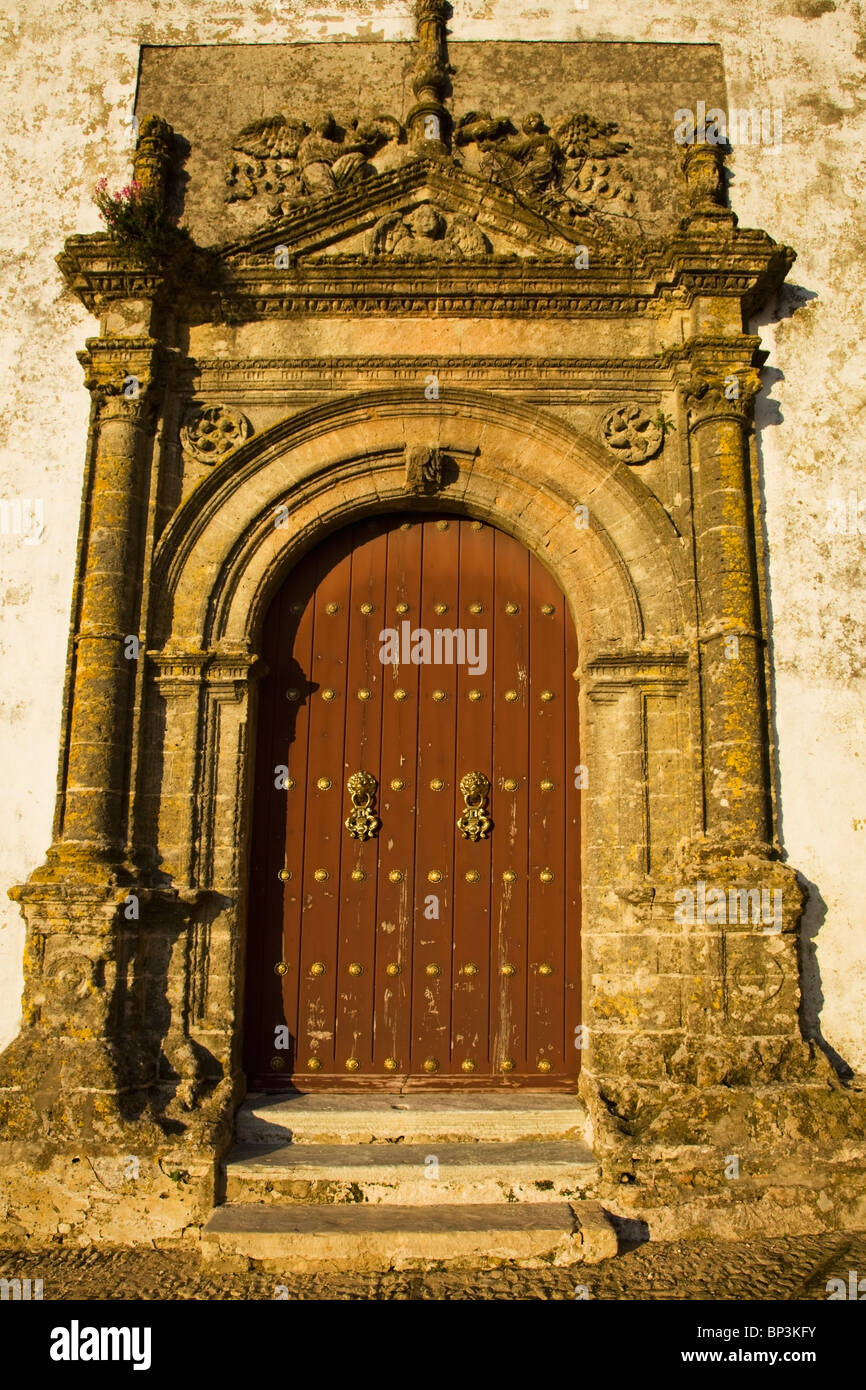 Medina Sidonia, Andalousie, Espagne ; la porte en bois à l'Iglesia Mayor avec un bâti en pierre ouvragée Banque D'Images