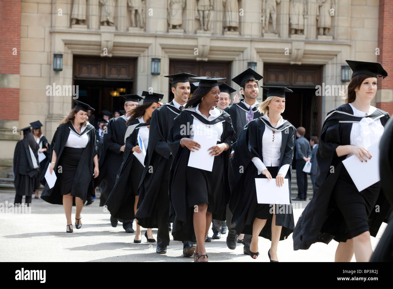 Diplômés quittent la grande salle après un diplôme à l'Université de Birmingham, UK cérémonie Banque D'Images