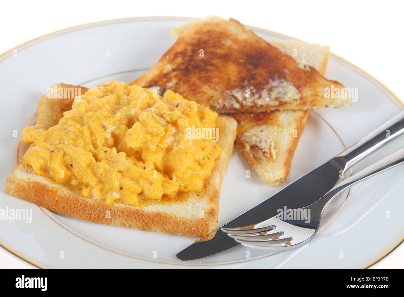 Un petit-déjeuner d'œufs brouillés sur toast, isolé sur un fond blanc. Banque D'Images