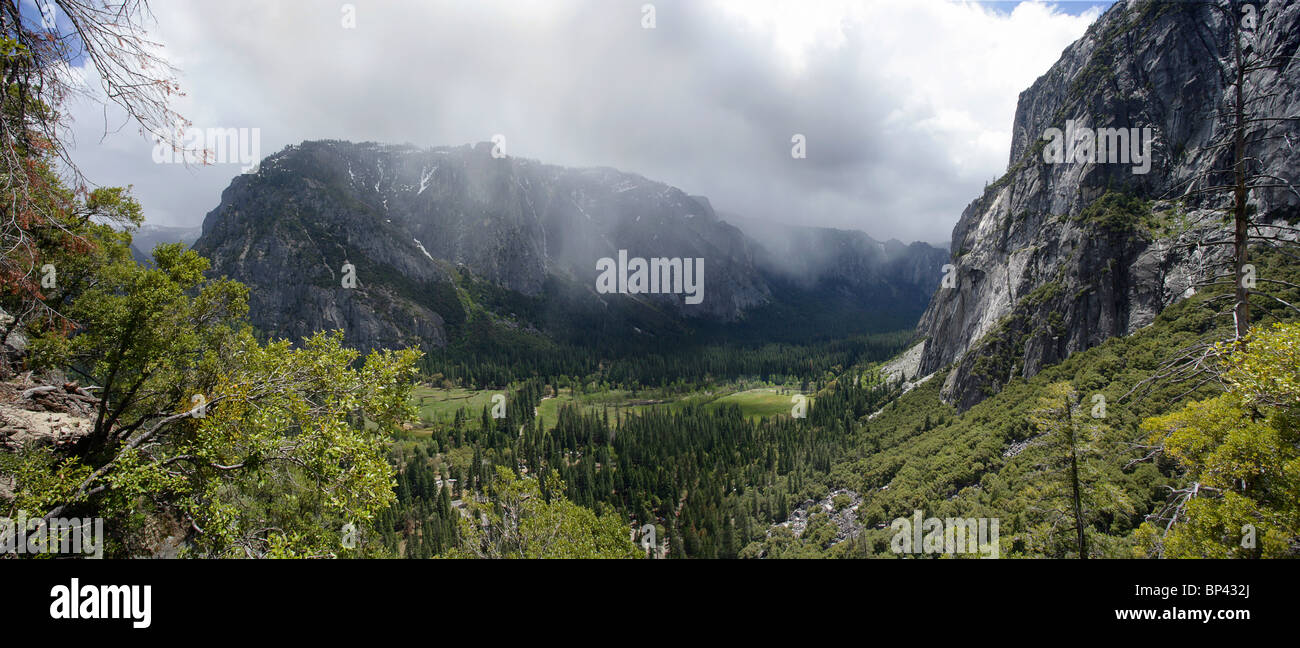 Une vue panoramique sur le Parc National de Yosemite avec nuages de neige venant à travers les montagnes. Banque D'Images