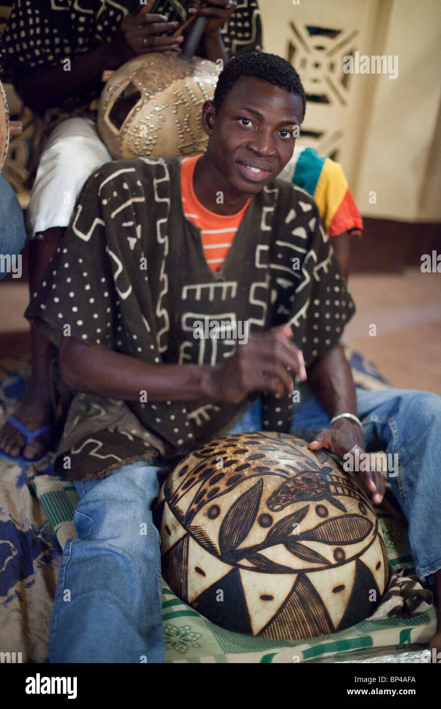 Un musicien du groupe, 'Benkadi de Ségou,' joue la calebasse au soleil du Minuit restaurant à Ségou, au Mali. Banque D'Images