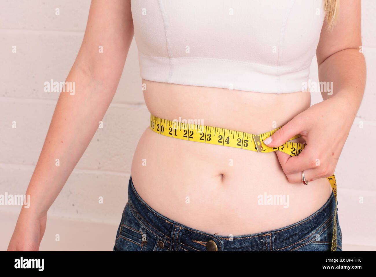 2010 juillet - Jeune femme mesurant sa taille de bordure Banque D'Images