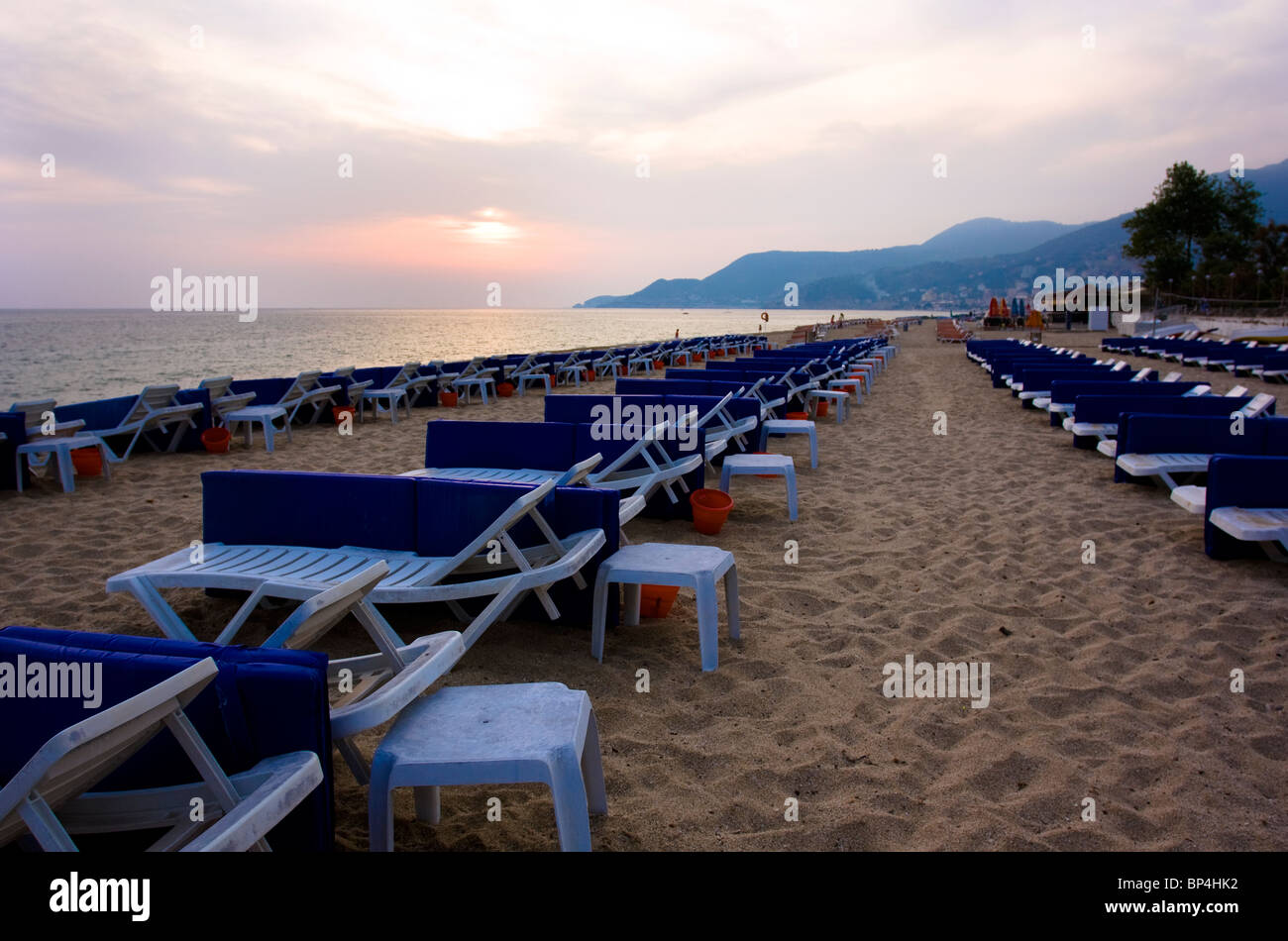 Des transats bordent la plage au coucher du soleil, Alanya, Turquie. Banque D'Images