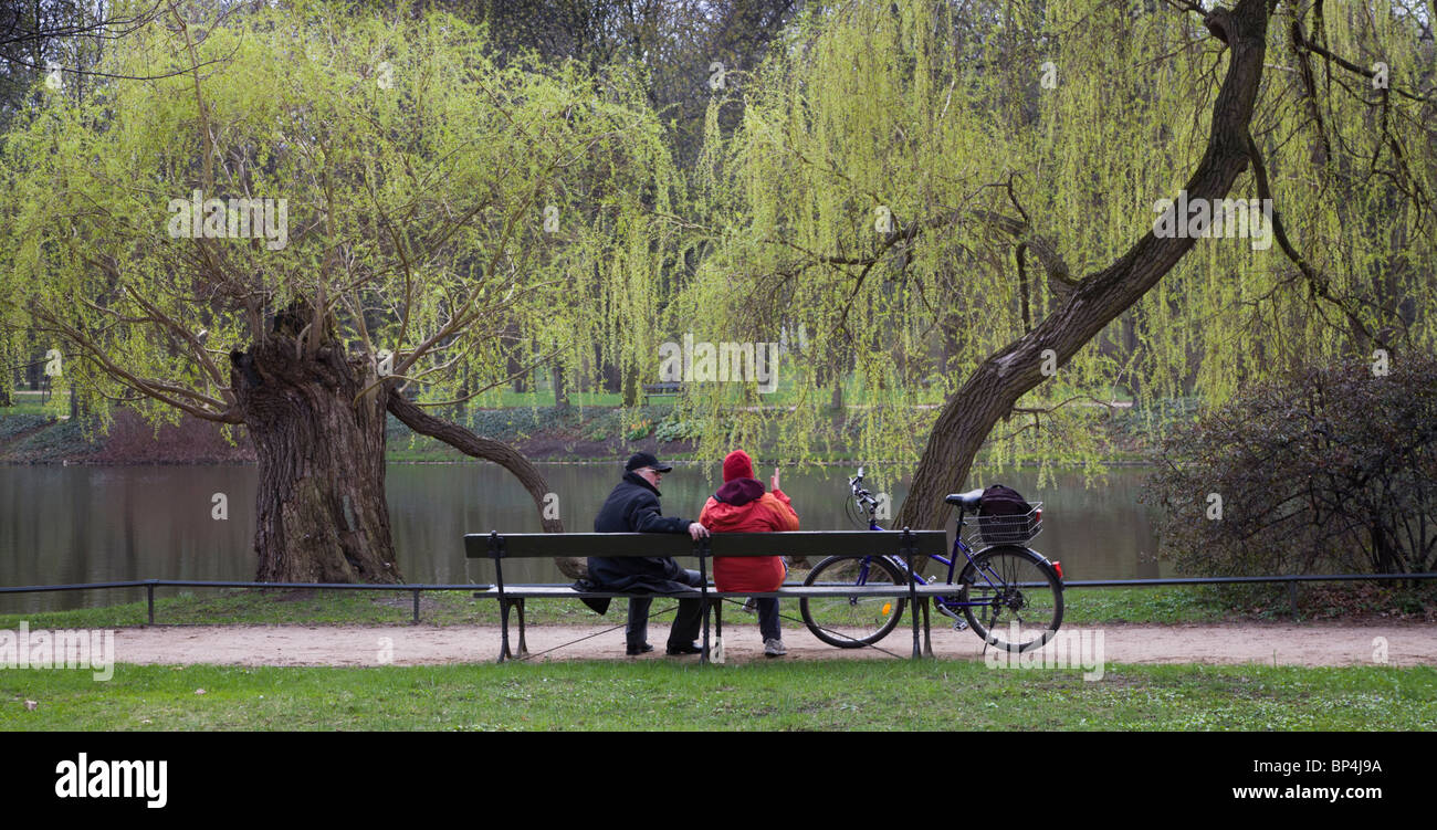 Des gens assis sur un banc au Parc des Thermes royaux, Varsovie Pologne Banque D'Images