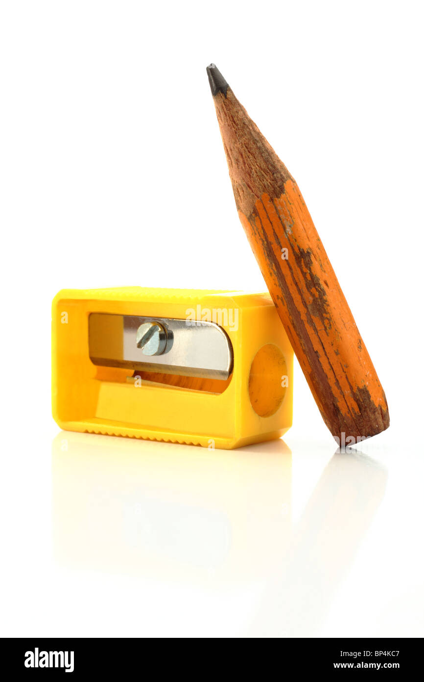 Un vieux crayon court presque entièrement utilisé avec un taille-crayon jaune reflète doucement sur un fond blanc Banque D'Images