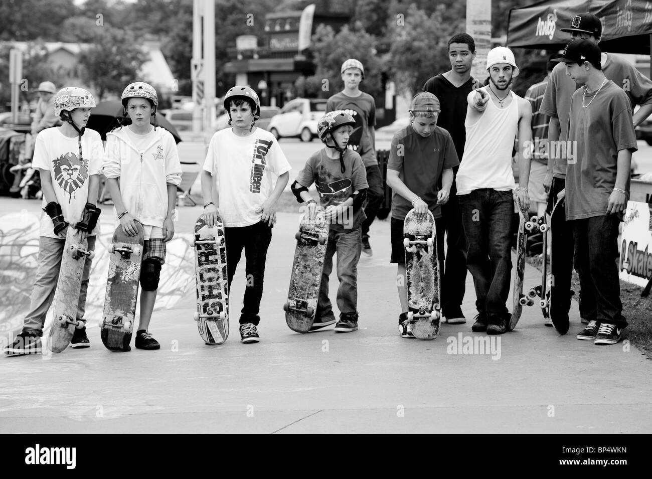 Un groupe de jeunes hommes skateboards description en une ligne à un parc de planche à roulettes. Banque D'Images