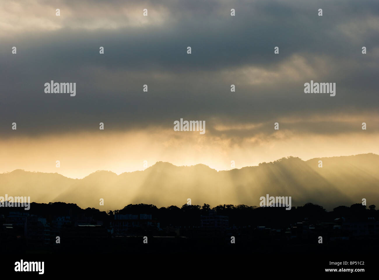 Soleil à travers les nuages gris et s'allument en montagnes. gradation Banque D'Images