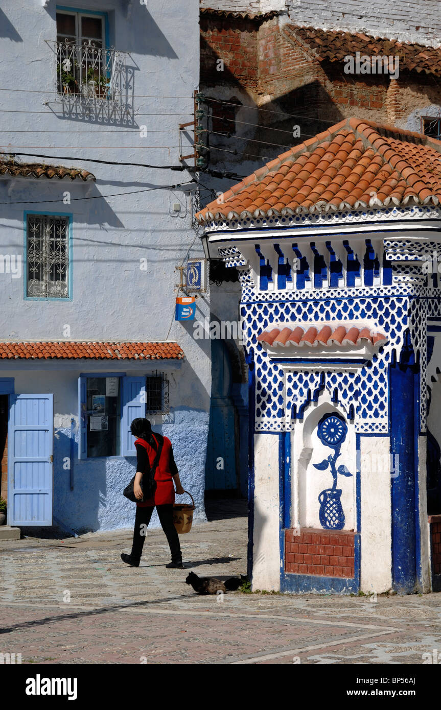 Place de la ville, fontaine publique & femme marocaine à aller chercher de l'eau, Chefchaouen, Maroc Banque D'Images