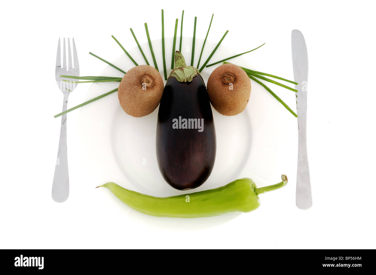 Visage fait de légumes et de fruits sur un plat. Isolé sur un fond blanc. Banque D'Images