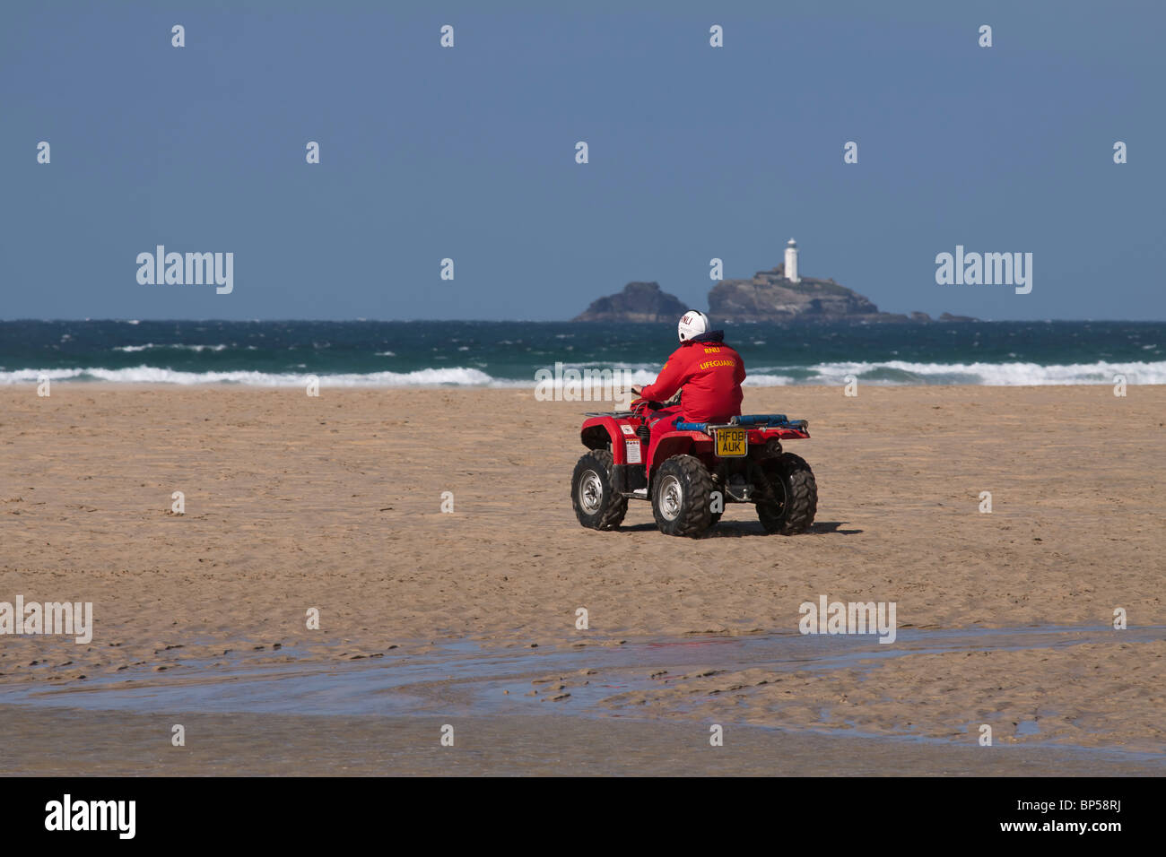 Lifeguard à patrouiller la plage de sable sur un quad Banque D'Images