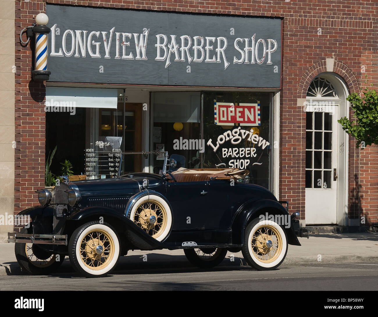 Un modèle Vintage Ford garée en face de l'ancien salon de coiffure shop USA Banque D'Images