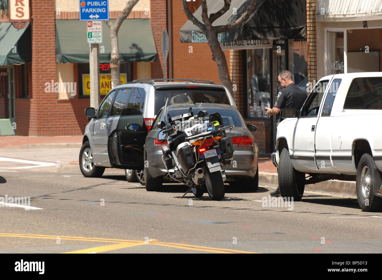 Question de la Police de la ville d'Orange une contravention à la femme à l'origine de cette BMW sur Chapman Avenue. Banque D'Images