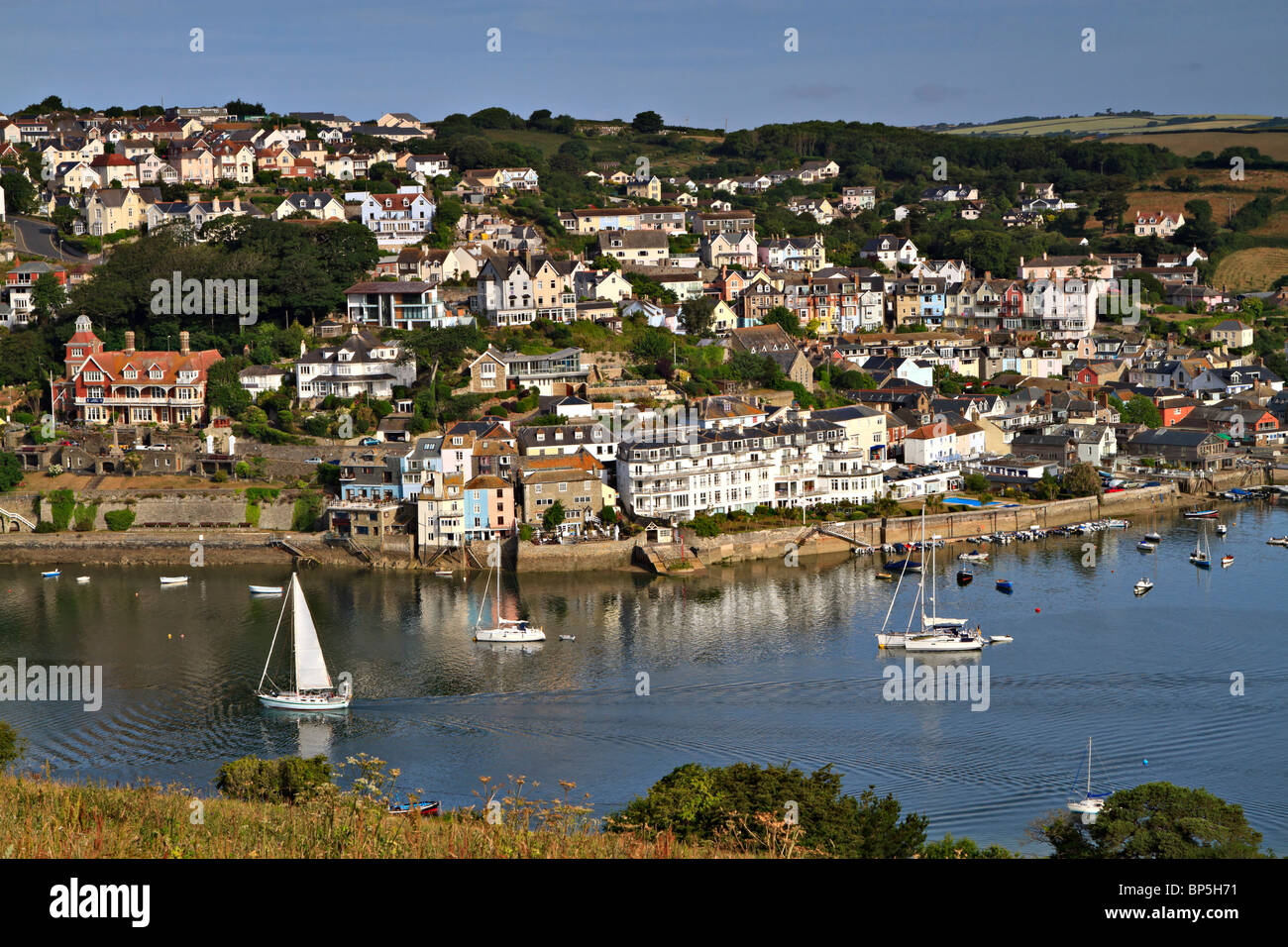 La ville et l'estuaire de Salcombe Portlemouth vers le bas. Un voilier fait son chemin vers la mer tôt le matin. Banque D'Images