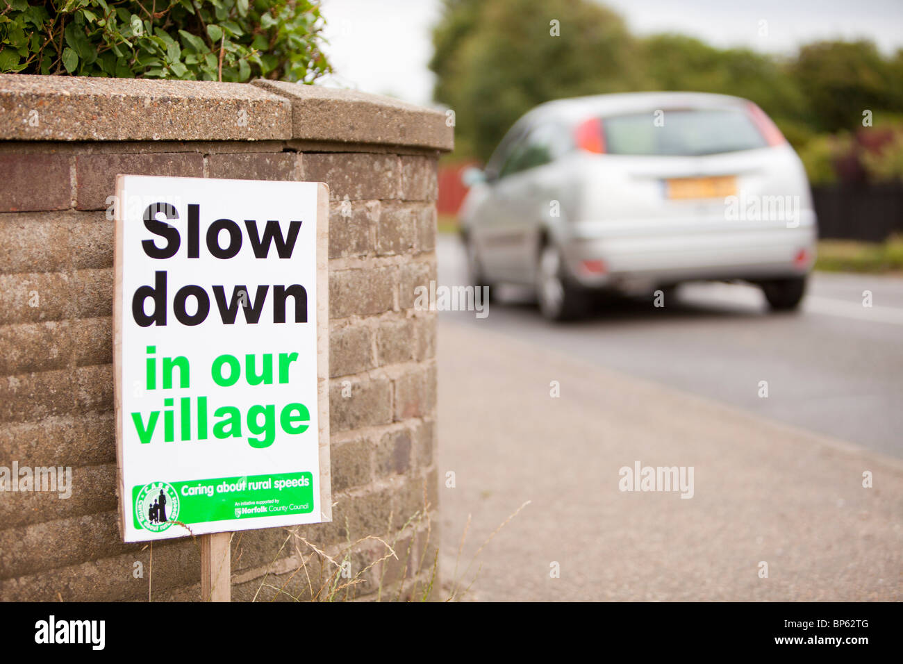 Un signe de demander aux automobilistes de ralentir à Mundesley village de Norfolk, Royaume-Uni. Banque D'Images