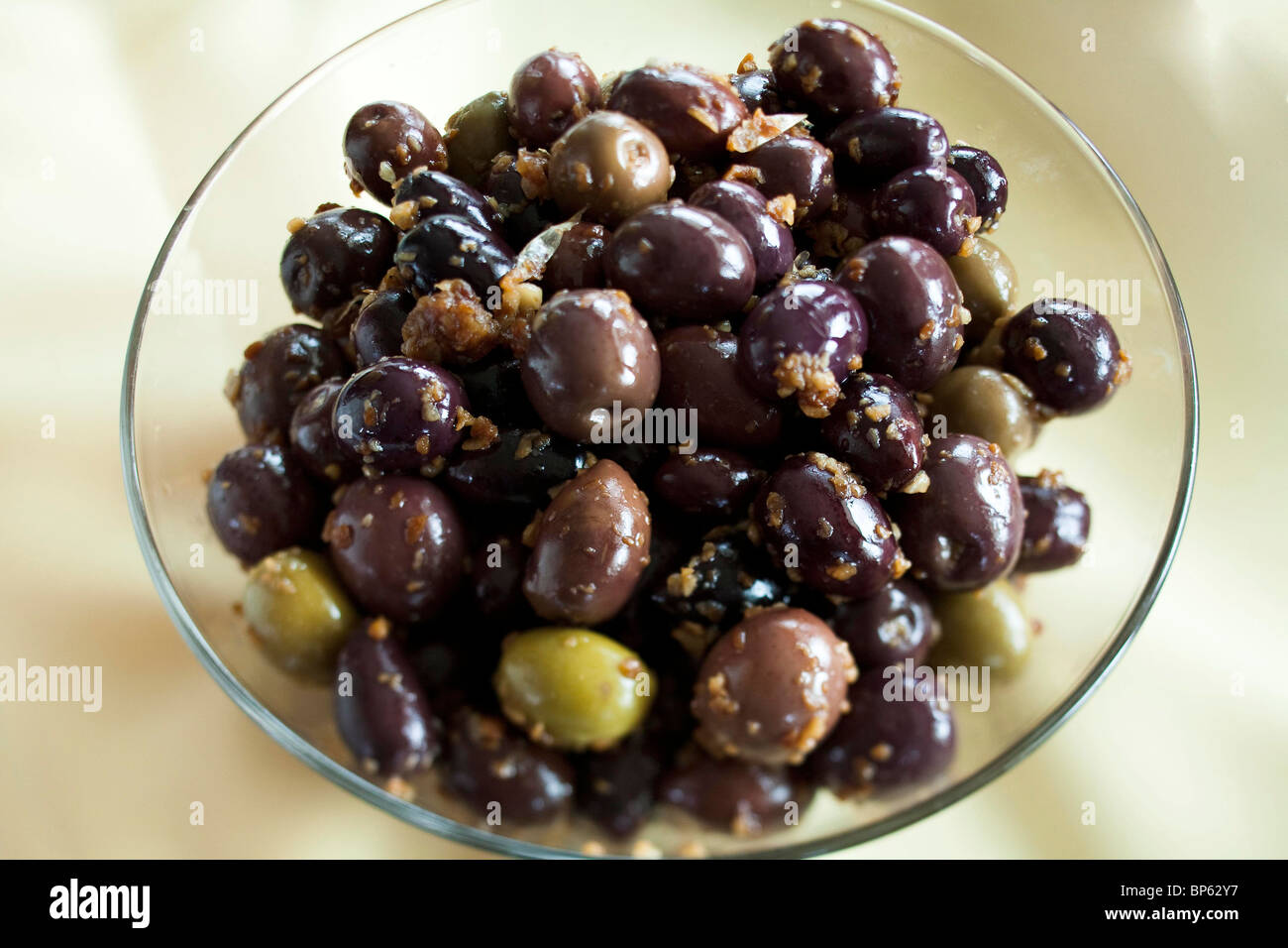 Les olives dans un bol sur une nappe jaune Banque D'Images