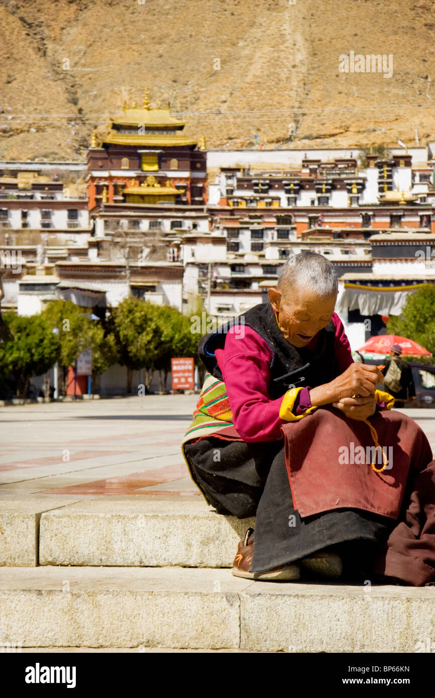 Un pèlerin prend un peu de repos en face de la monastère de Tashilhunpo à Shigatse, Tibet, Chine. 2010 Banque D'Images