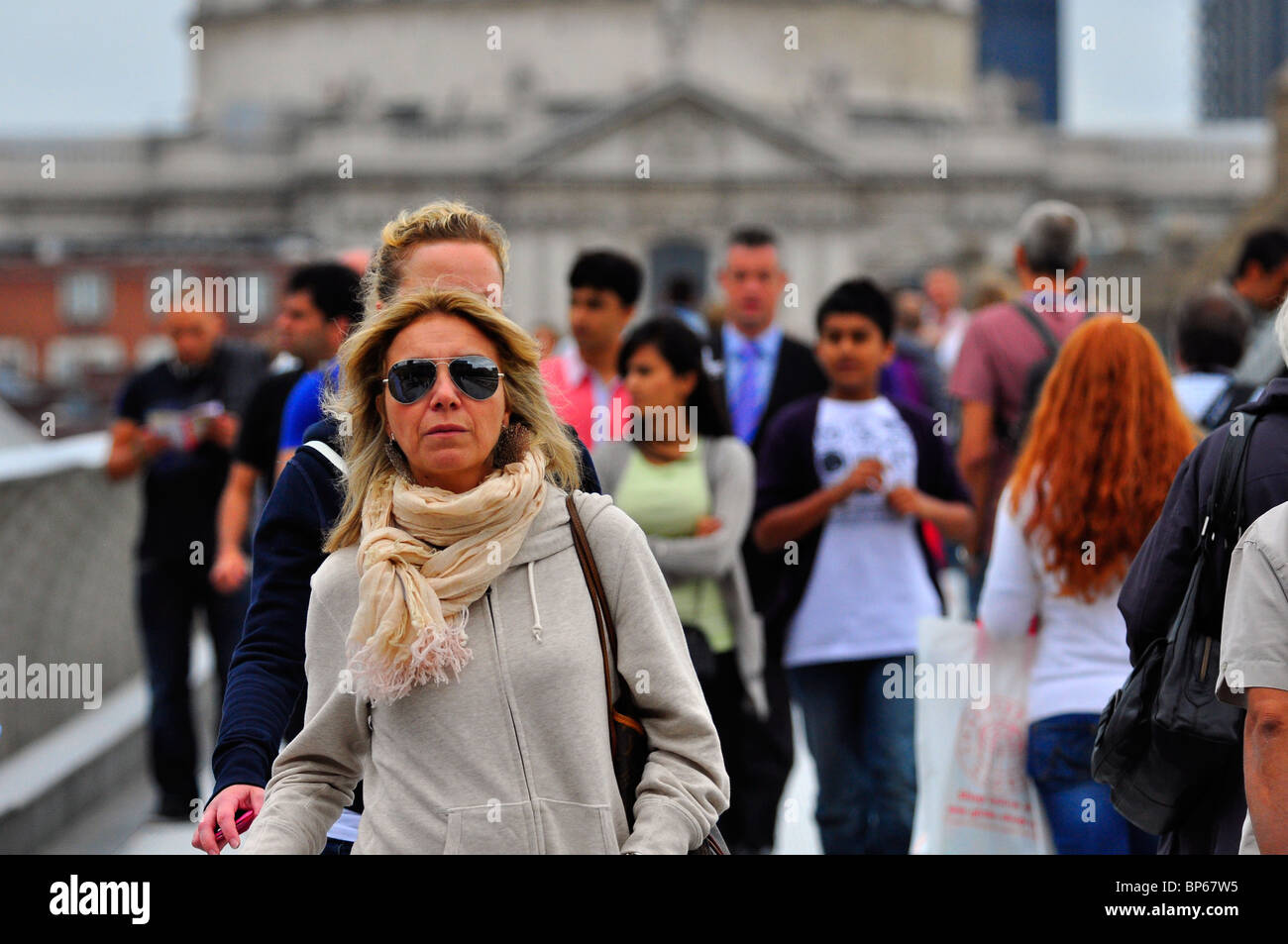 Femme avec des lunettes de soleil en traversant le pont du millénaire Banque D'Images
