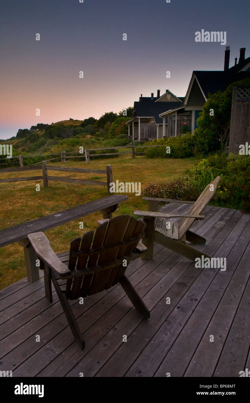 Des chaises longues en bois avec vue sur l'océan de guest cottages au coucher du soleil, Albion River Inn, Albion, Mendocino County, Californie Banque D'Images