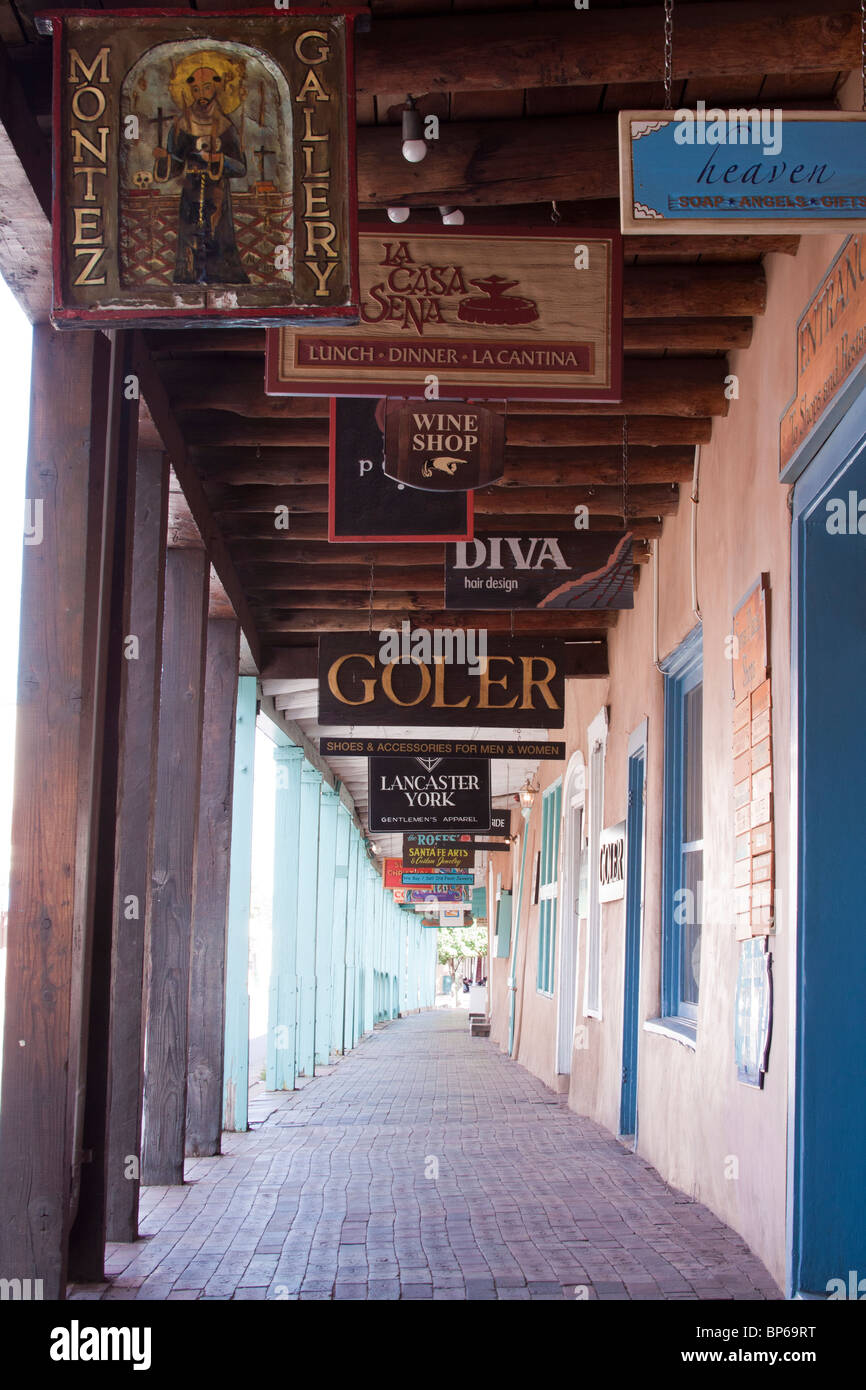 Enseignes de bois colorés pour les galeries, boutiques et restaurants bordent un portique à Santa Fe, Nouveau Mexique Banque D'Images