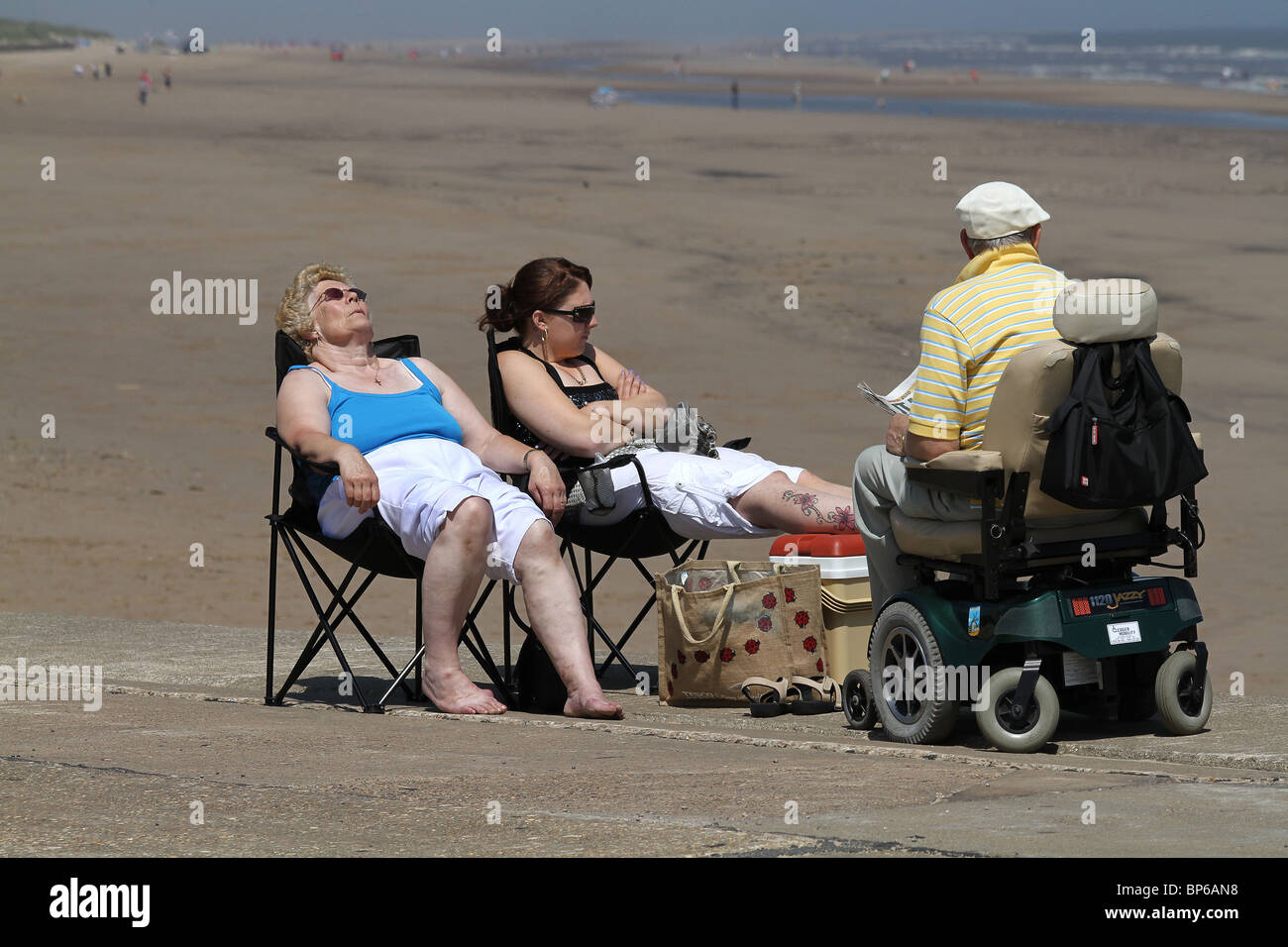 Détente au soleil avec la vieille personne en fauteuil roulant électrique. Banque D'Images