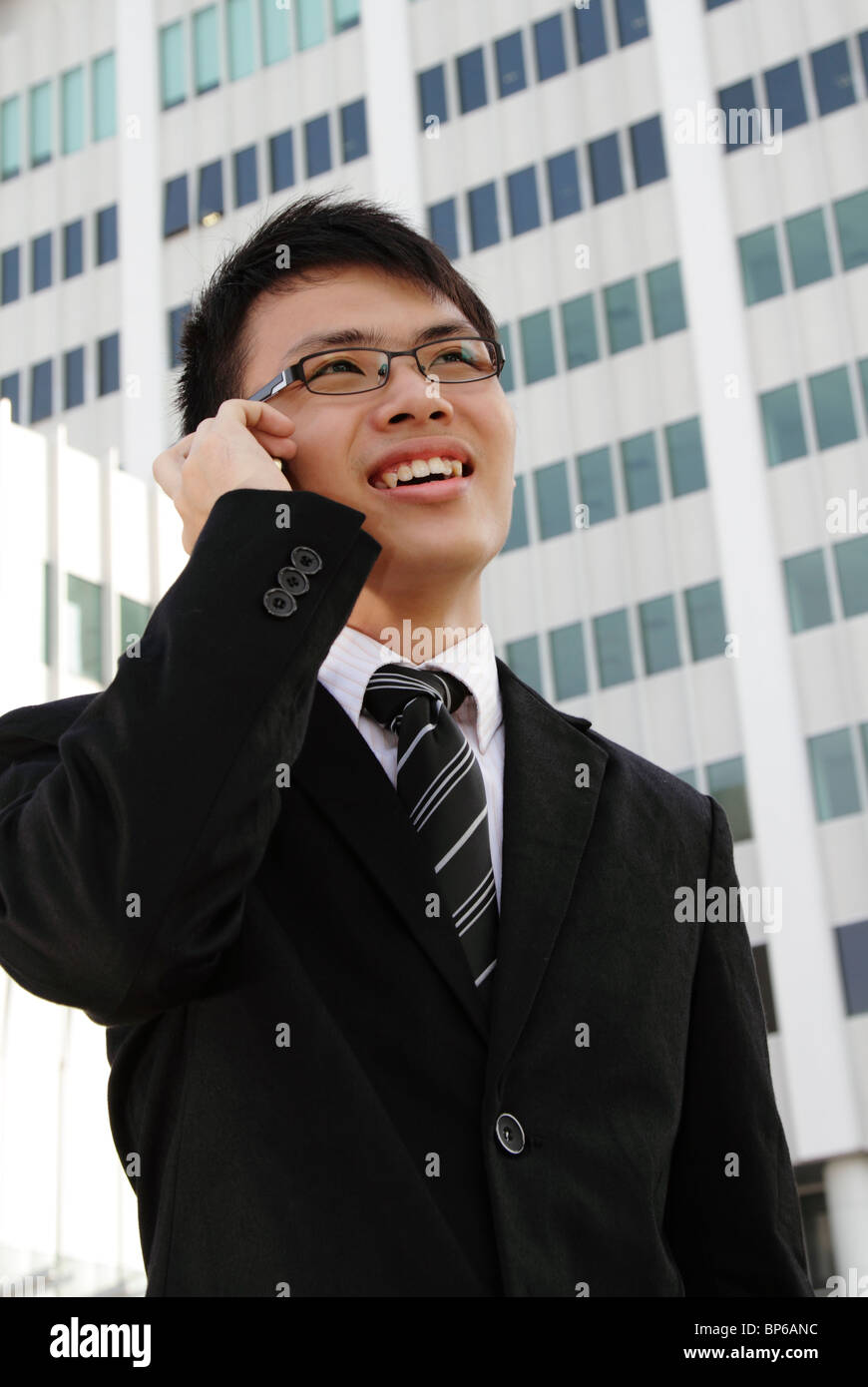 Un jeune homme asiatique parlant au téléphone Banque D'Images