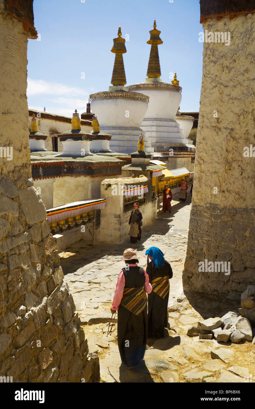 Un pèlerin à pied famille autour de stupas situé dans le monastère de Tashilhunpo de cours intérieures à Shigatse, Tibet, Chine. 2010 Banque D'Images