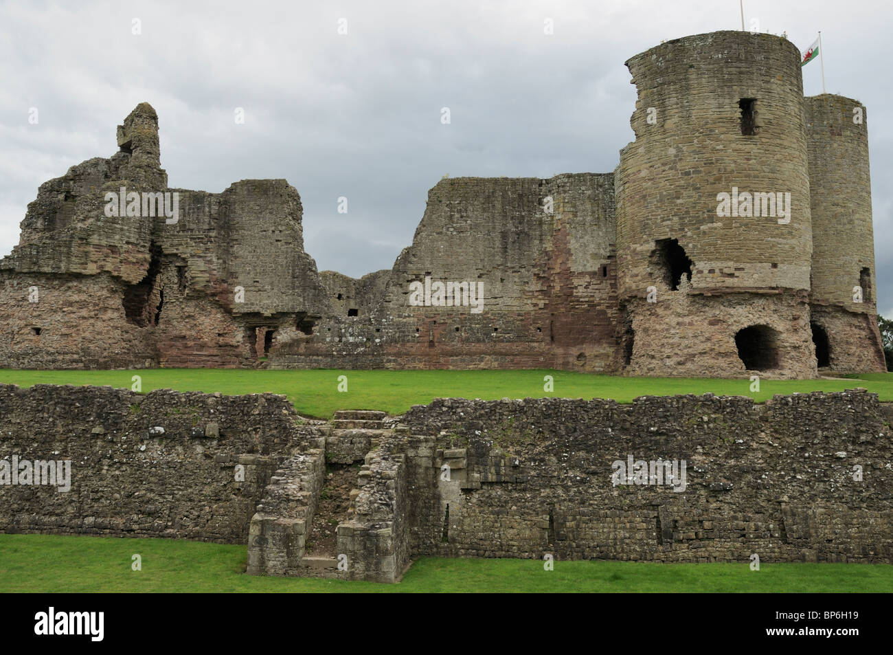 Les ruines de château Rhuddlan vu contre un ciel gris de couvaison de l'ensemble du fossé sec, Rhyl, au nord du Pays de Galles Banque D'Images