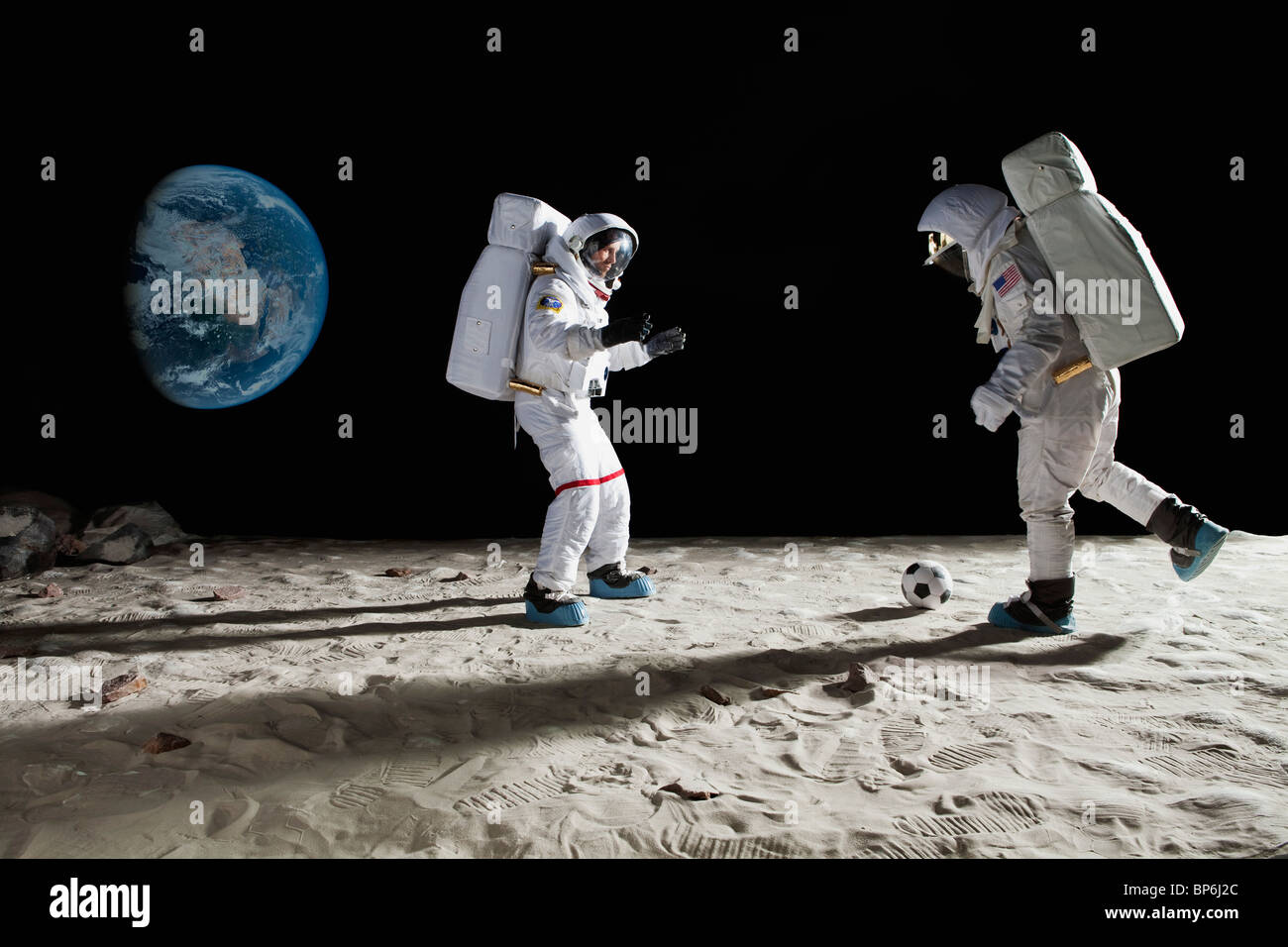 Deux astronautes jouant au football sur la lune Banque D'Images