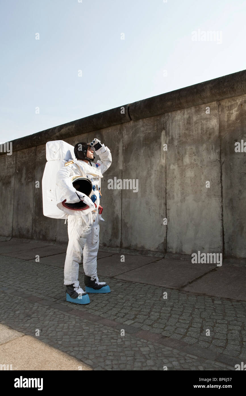 Un astronaute sur un trottoir de la ville à la recherche dans le ciel Banque D'Images