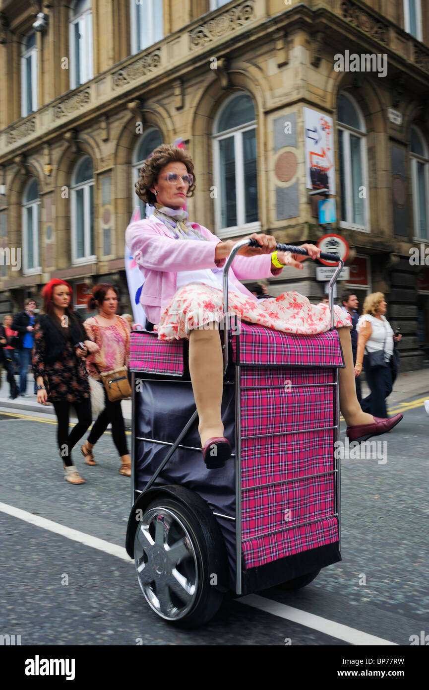 Les hommes habillés comme des vieilles dames à cheval sur l'utilisation d'un Segway fait comme des paniers à Liverpool à l'événement gay pride - Août 2010 Banque D'Images