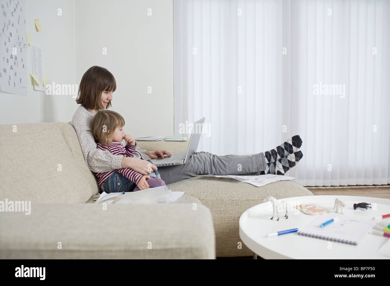 Mère et fille avec un ordinateur portable dans la salle de séjour Banque D'Images