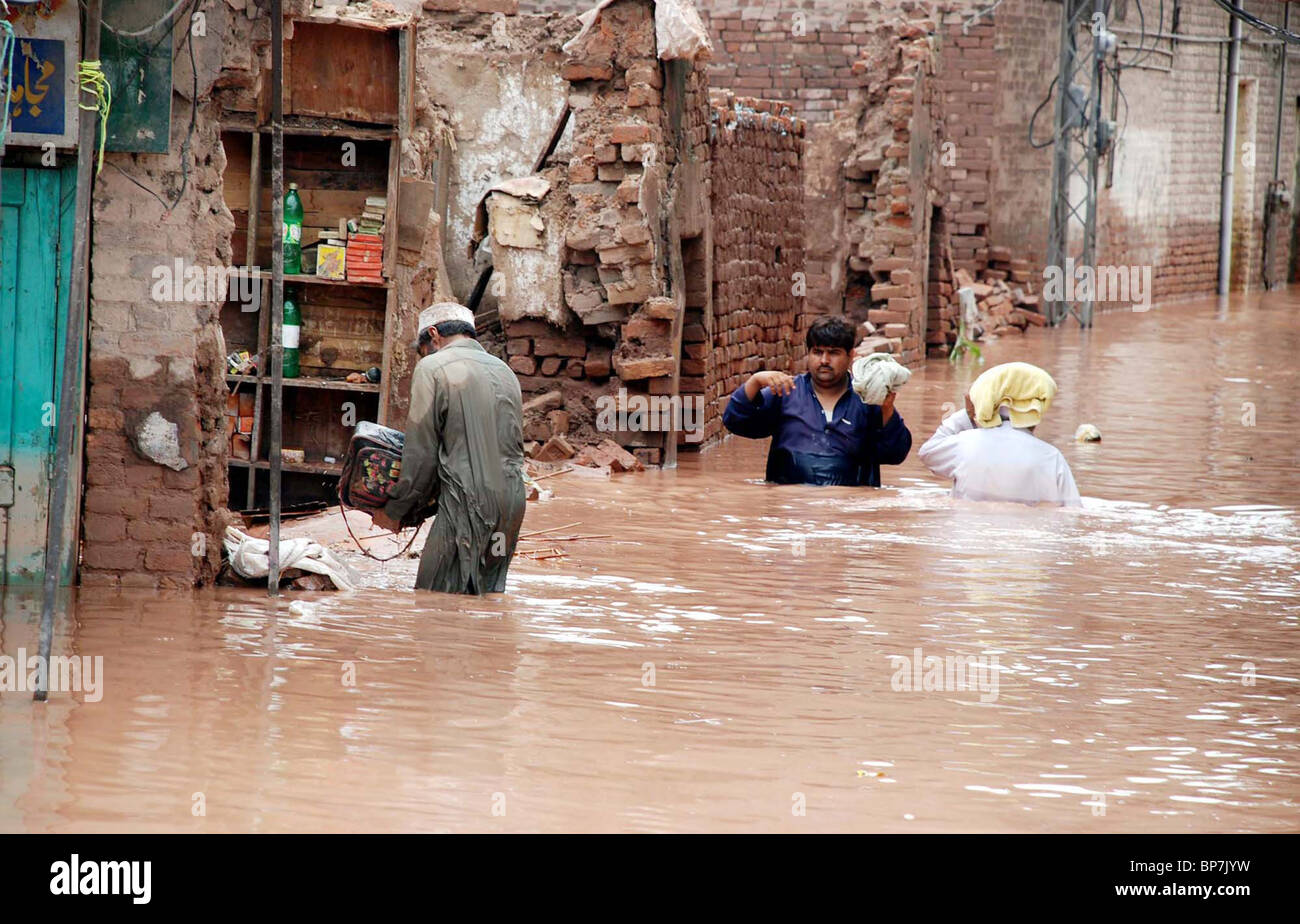 Les victimes les gens passent leurs biens vers l'endroit sûr après inondation à Pabbi salon à Peshawar Banque D'Images