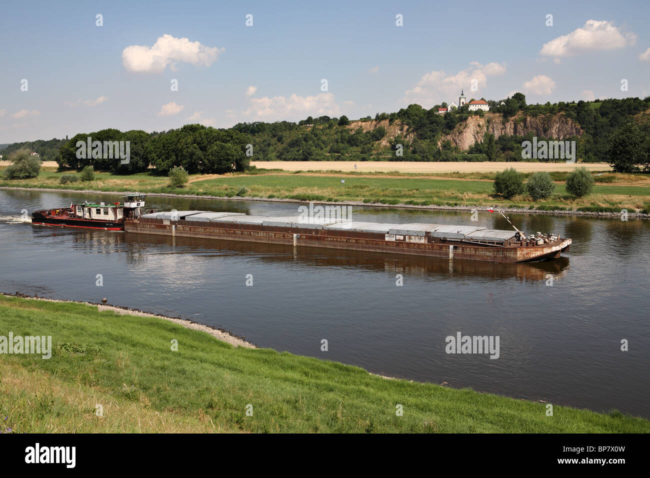 Un pousseur barge passe Zadel église sur la rivière Elbe vue depuis le chemin du cycle de l'Allemagne, de l'Europe Banque D'Images