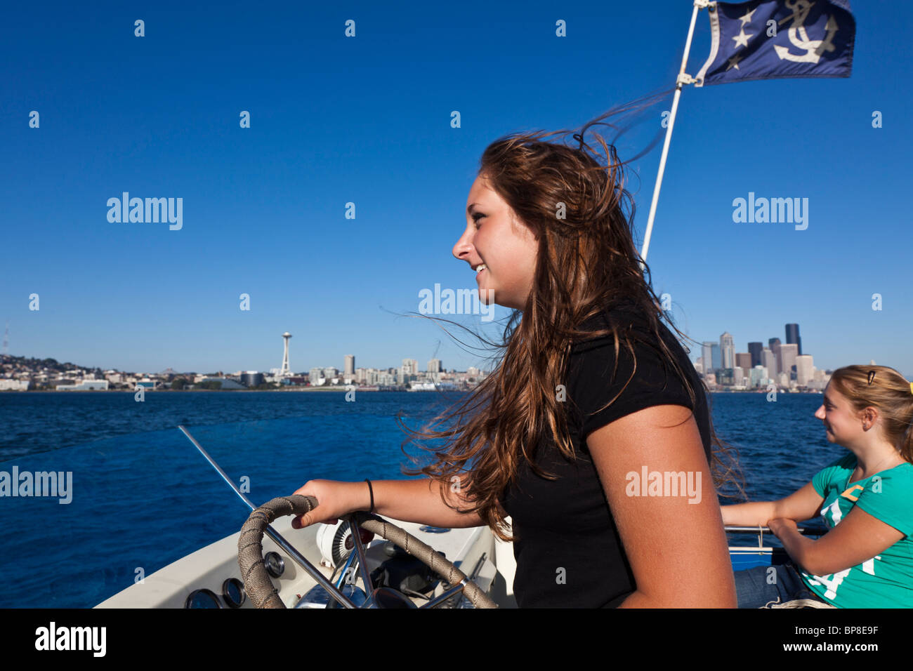 Adolescente yacht pilotes sur la baie Elliott avec Seattle skyline en arrière, Seattle, Washington Banque D'Images