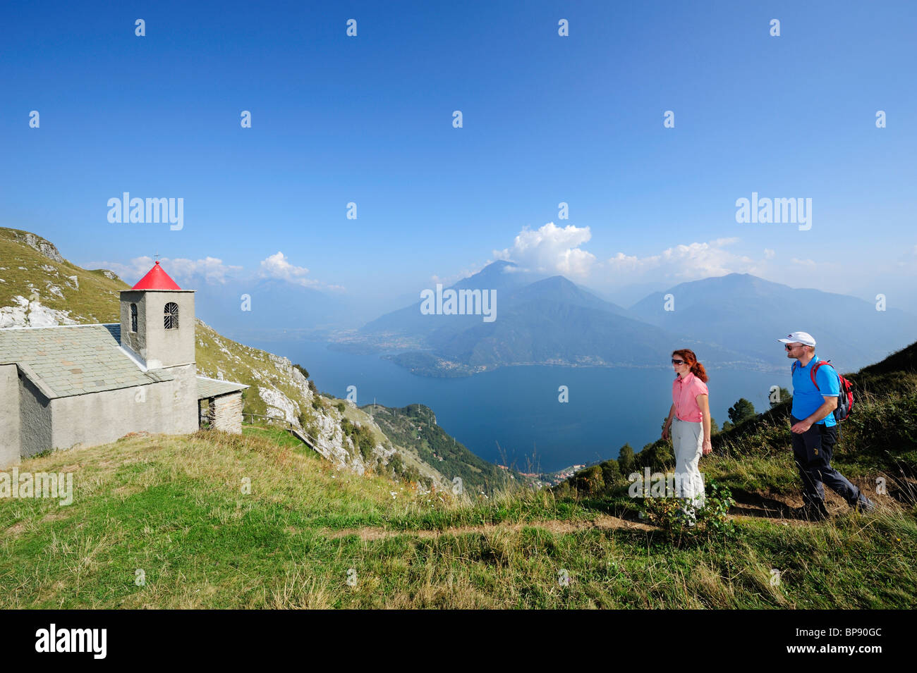 Deux randonneurs près de San Bernardo chapelle, Monti Lariani en arrière-plan, le lac de Côme, Lombardie, Italie Banque D'Images