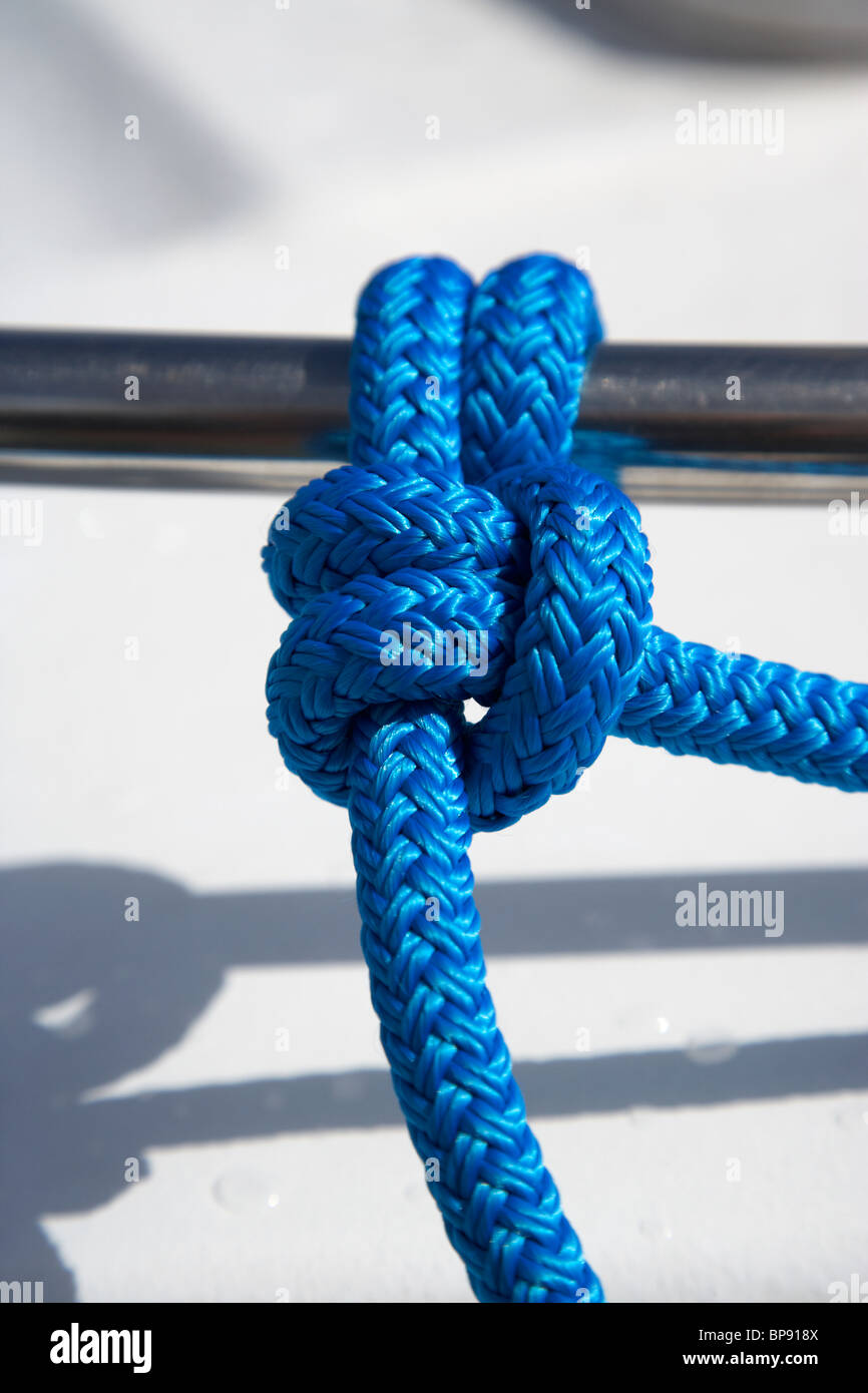 Corde bleu dans un tour mort et deux demi-clefs à un bateau en acier rail au Royaume-Uni Banque D'Images