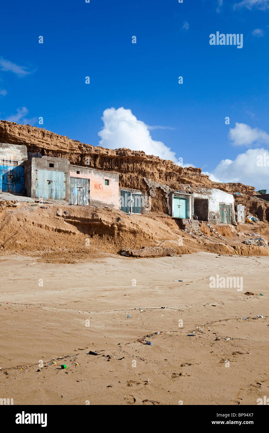 Plage d'Aglou avec des maisons de pêcheurs nichés dans la falaise, Tiznit, côte Atlantique, sud du Maroc Banque D'Images