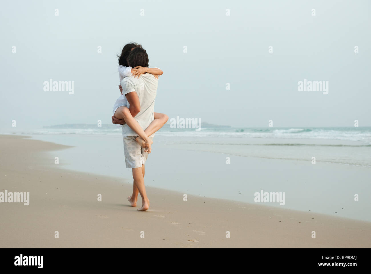 Tarifa, Cadix, Andalousie, Espagne ; un couple en train de marcher sur le sable à la plage de los lances le long de la costa de la luz Banque D'Images